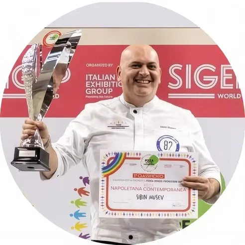 Unser Pizzabäckermeister hält Pokal und Urkunde „1° Classificato — Napoletana Contemporanea“ in die Höhe